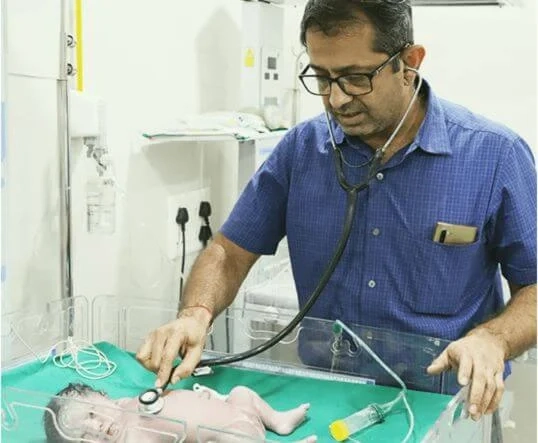 Dr Yeshwant Mane examining newborn baby at Atharva Infertility Centre Nashik - Best IVF Specialist