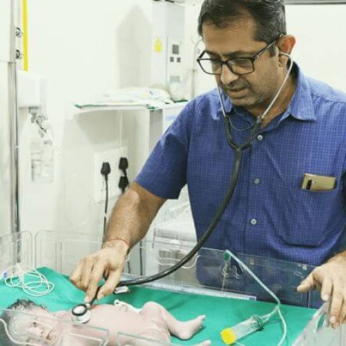 Dr Yeshwant Mane examining newborn baby at Atharva Infertility Centre Nashik - Best IVF Specialist
